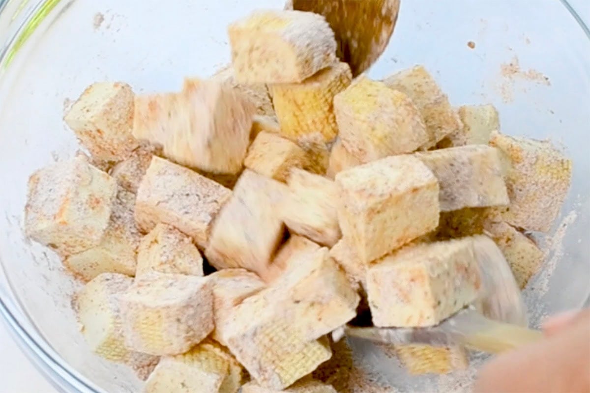 seasoning raw tofu in a bowl.