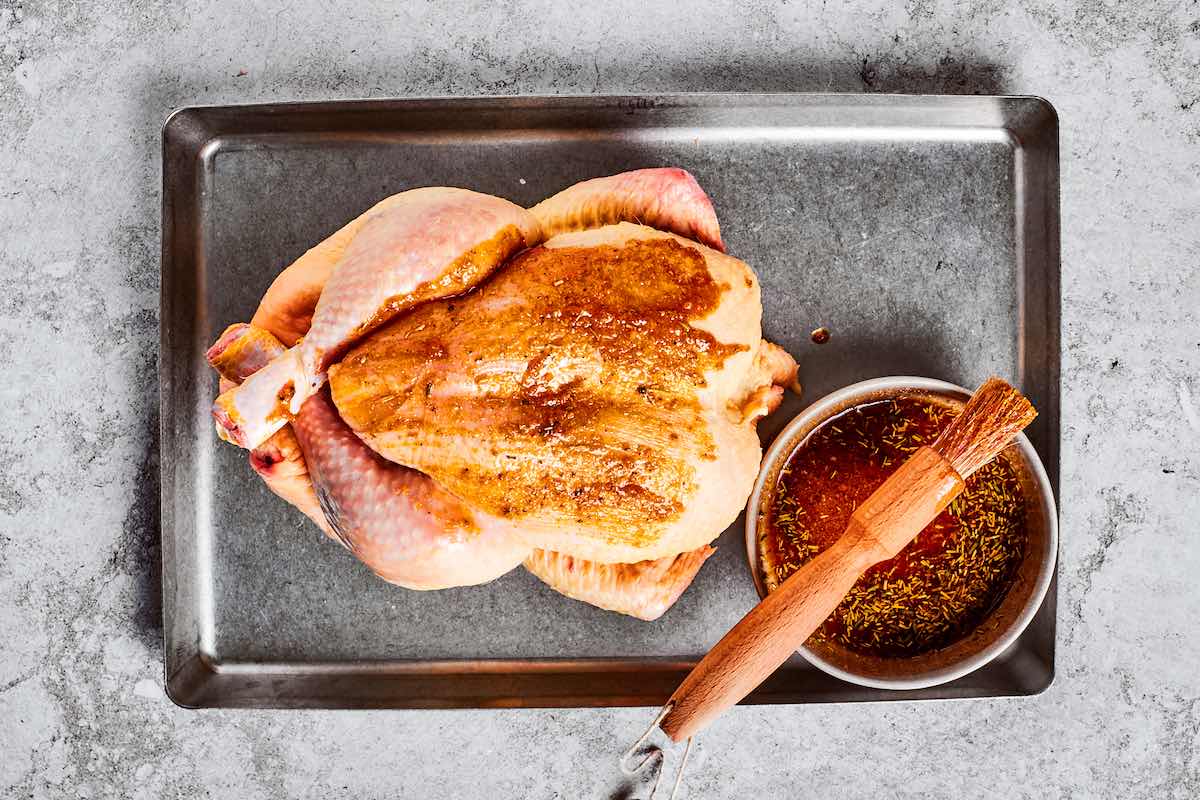 basting raw chicken with seasoned, melted butter.