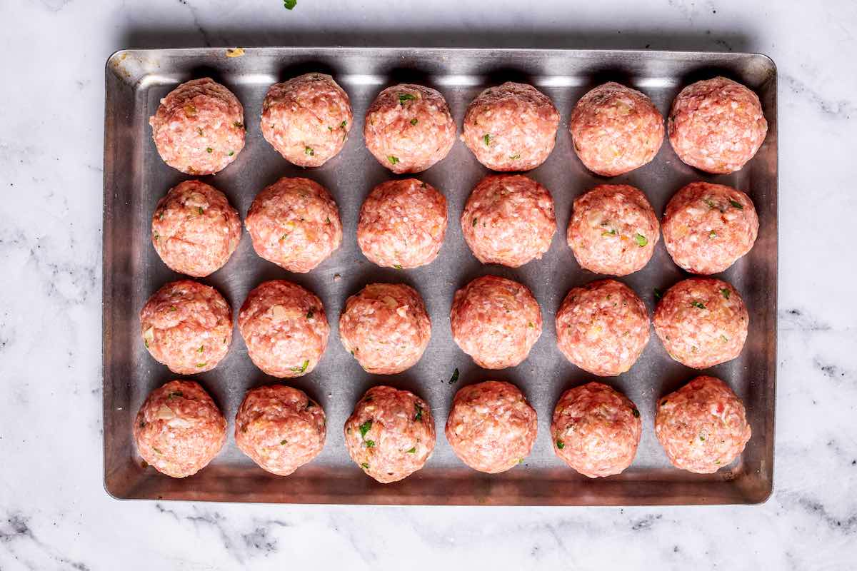 shaped, raw pork meatballs on a tray.