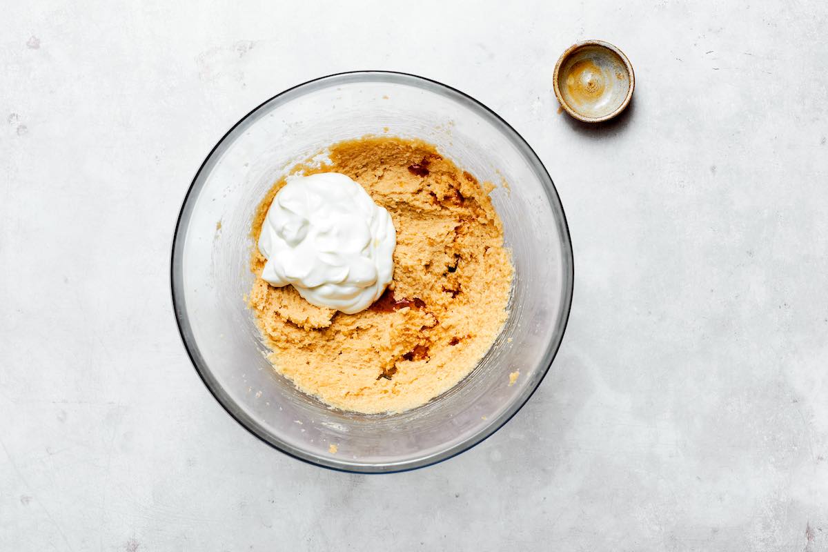 adding Greek yogurt to dough.