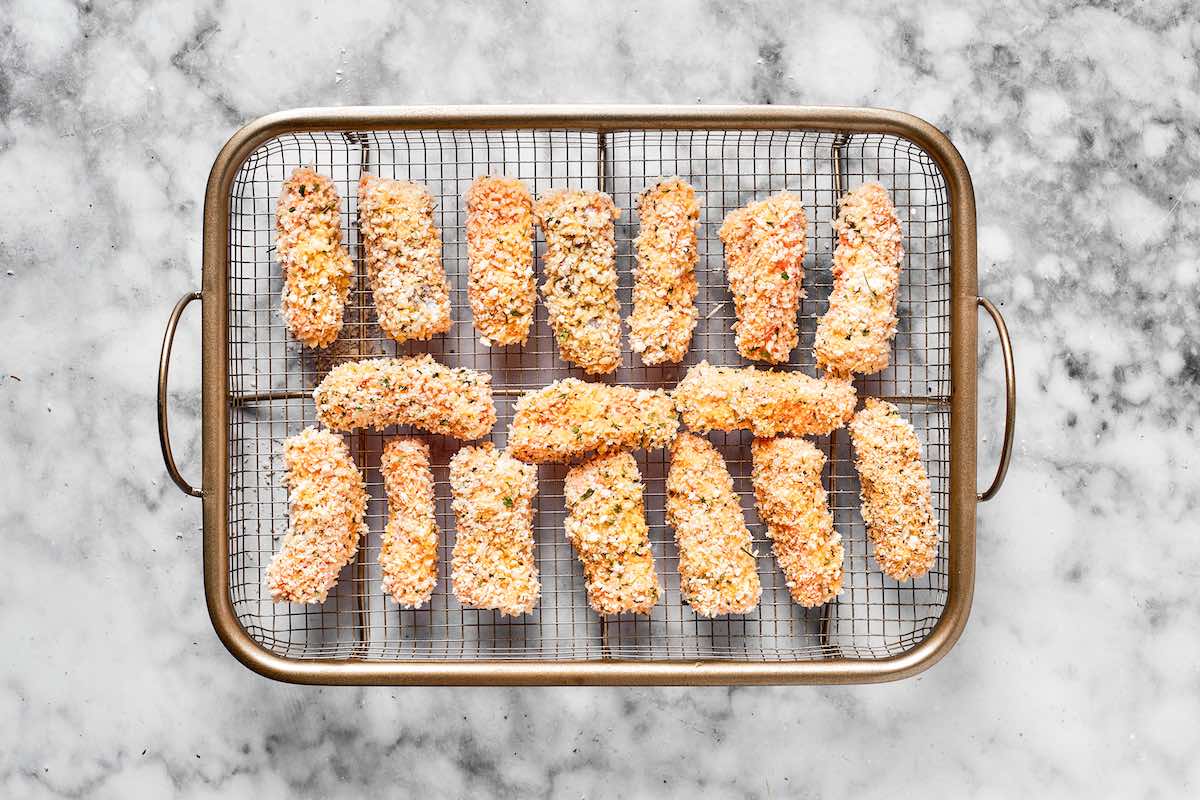 breaded fish sticks on a wire rack.