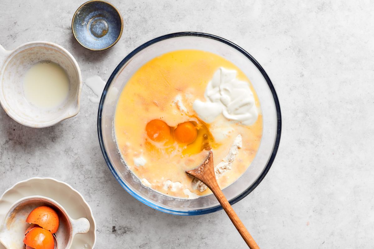eggs, flour, yeast, butter, cottage cheese, and milk in a bowl.