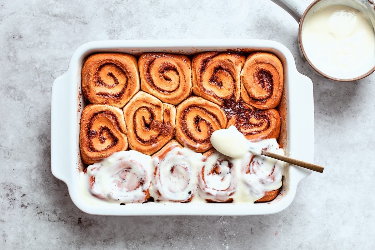frosting warm cinnamon rolls.
