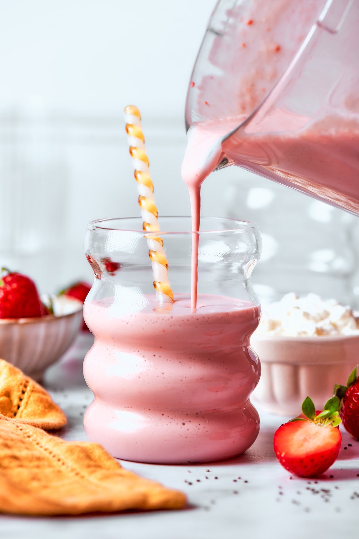 pouring cottage cheese smoothie in a glass.