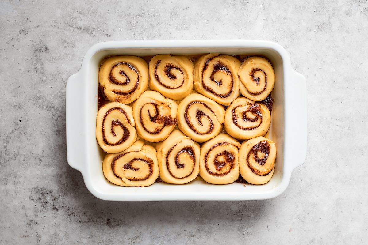 shaped unbaked rolls in baking dish.