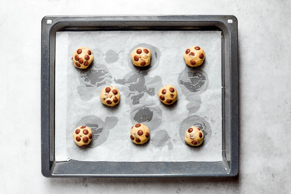 shaped balls of cookie dough on a baking sheet.
