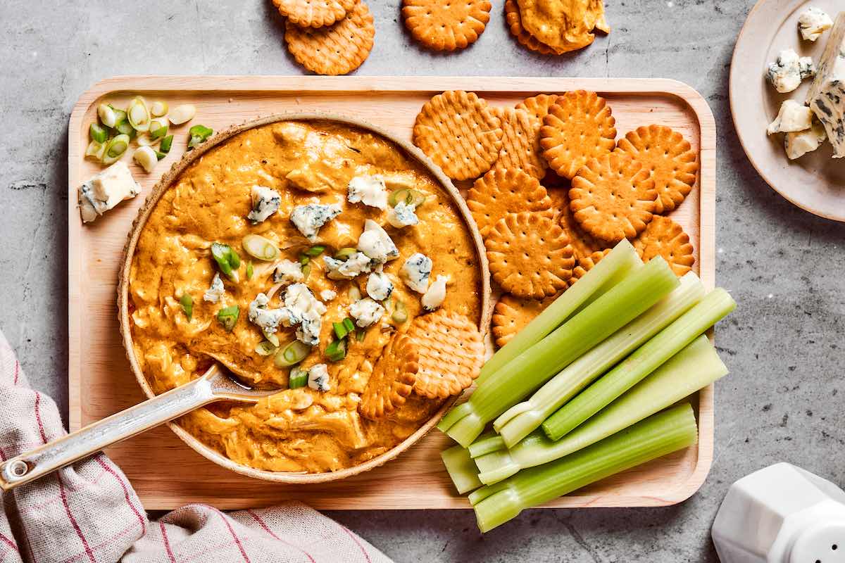 buffalo chicken dip in a bowl with celery and crackers.