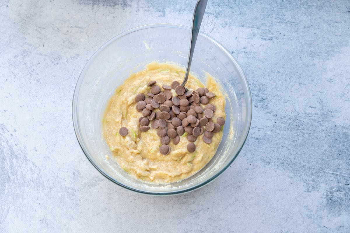 zucchini bread batter in mixing bowl with chocolate chips folded through.