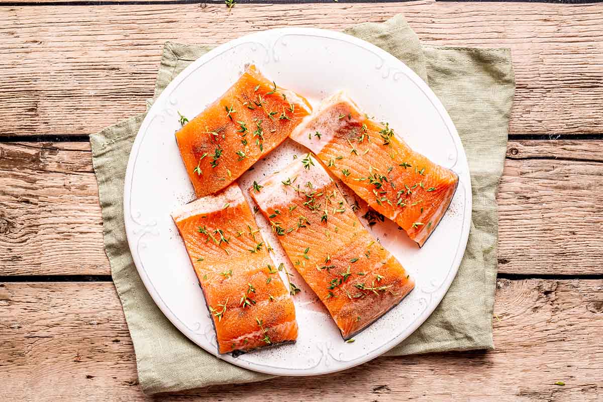 seasoned raw steelhead trout fillets on a plate.