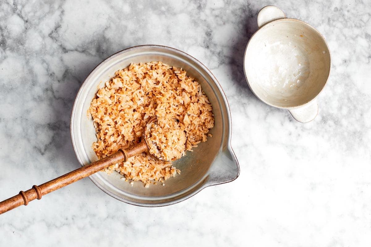 mixing day old rice with seasonings in a bowl.
