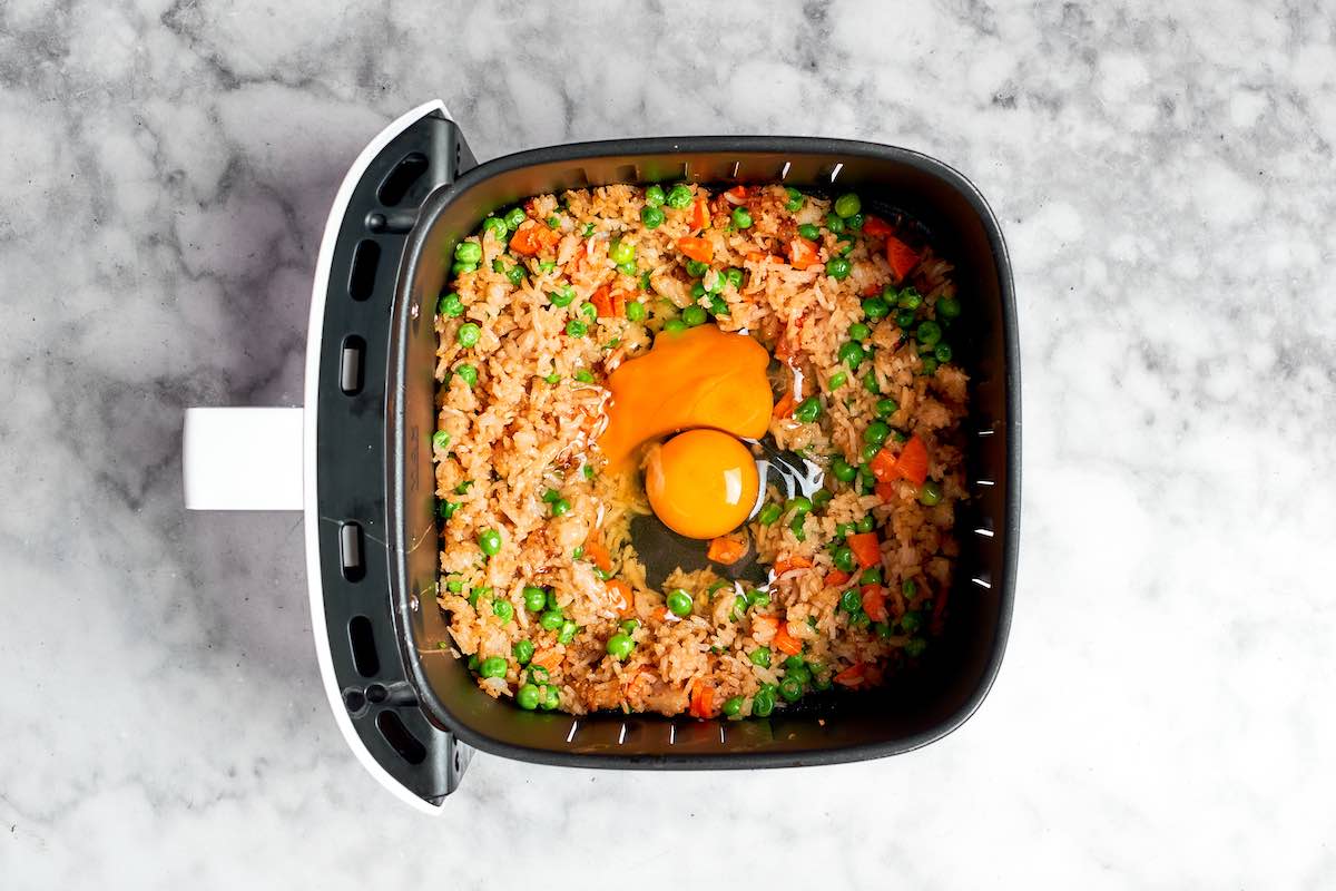 raw egg added to fried rice in air fryer.