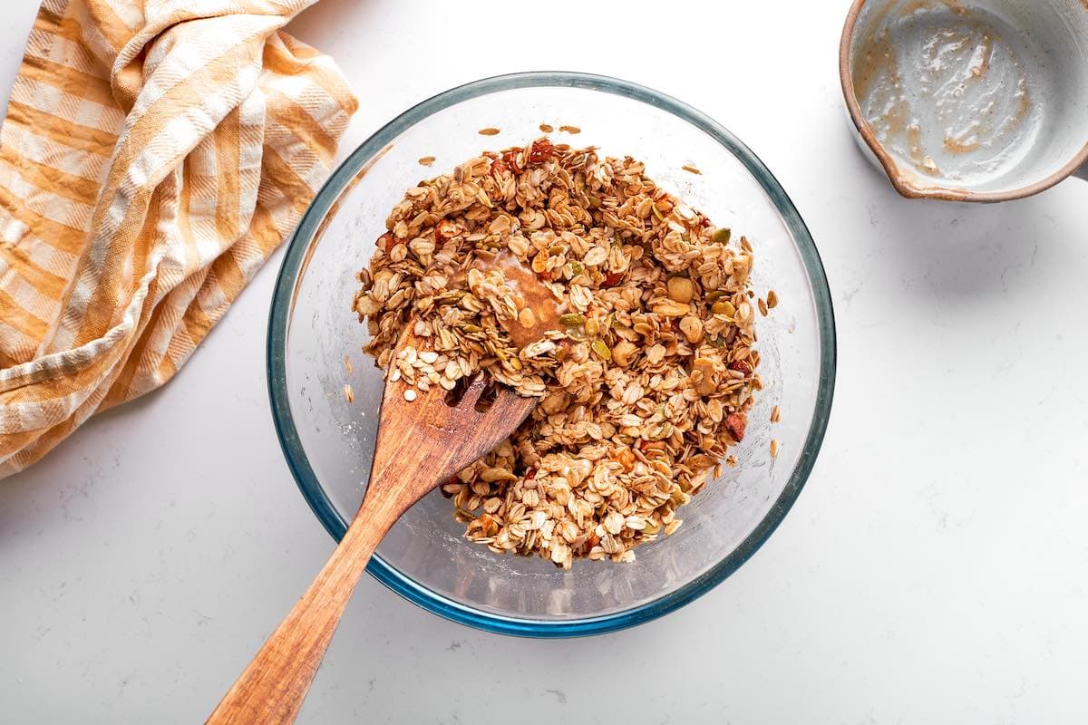 mixing granola mixture in a bowl.