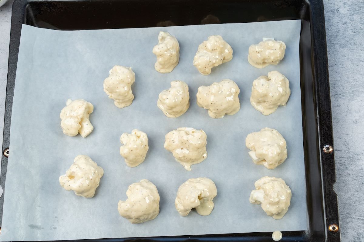 baking sheet with battered cauliflower pieces on top.