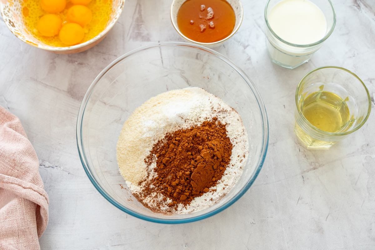 coconut flour, arrowroot starch, cocoa powder, salt, baking powder, and baking soda in a clear bowl.