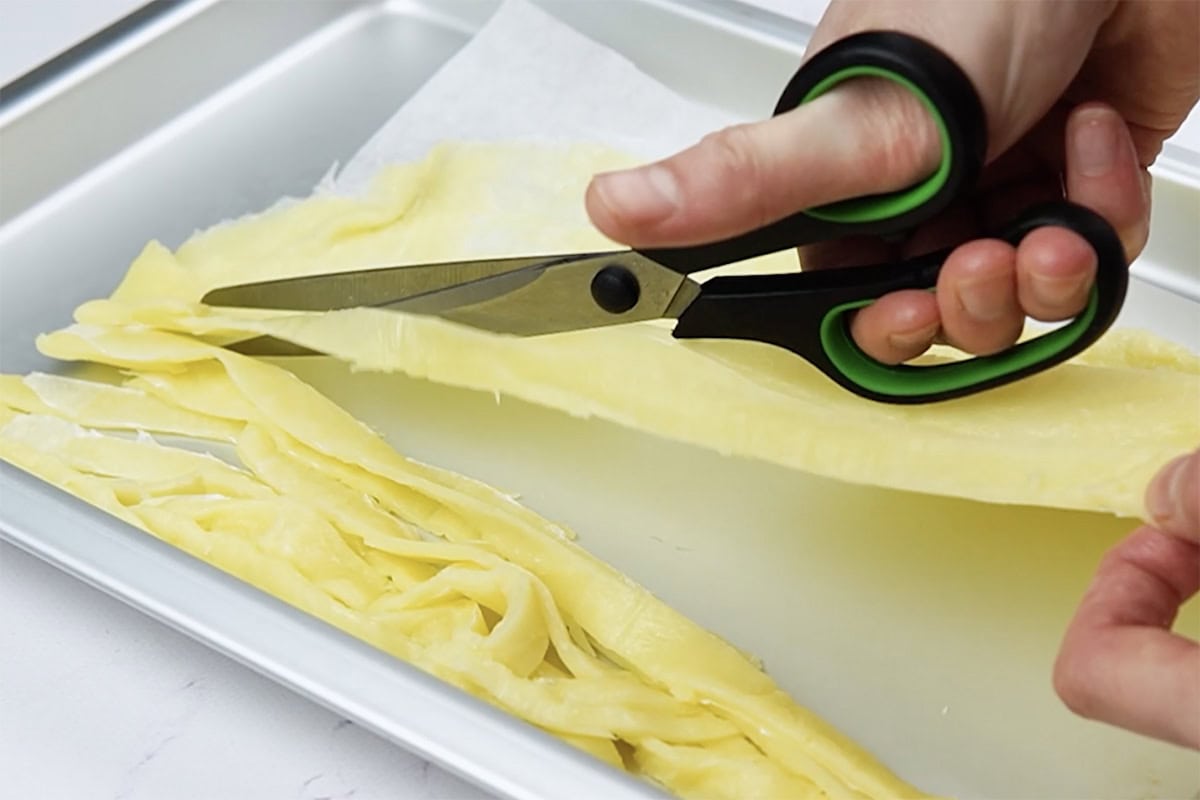 cutting frozen keto pasta into noodles.