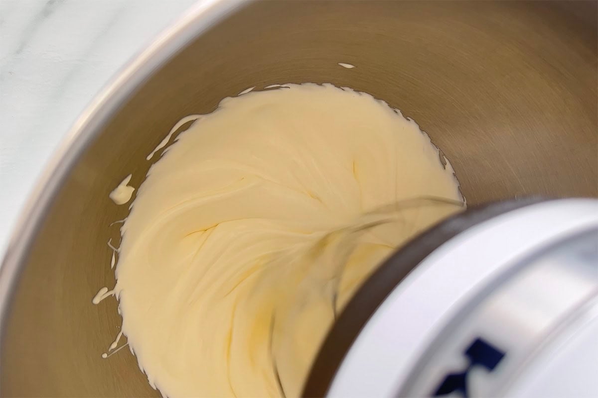 whipping coconut milk in a mixing bowl.
