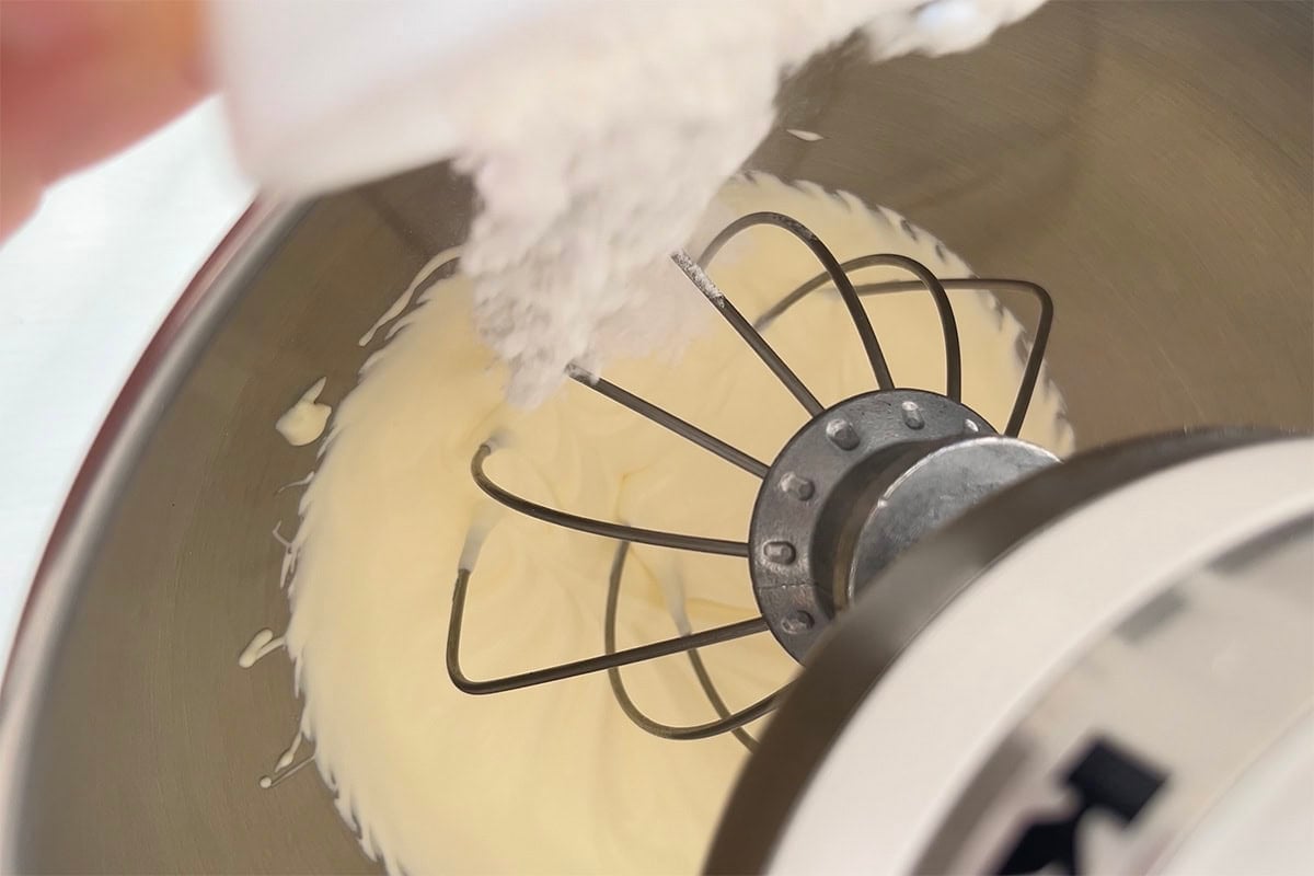 adding powdered sweetener to whipped coconut milk.