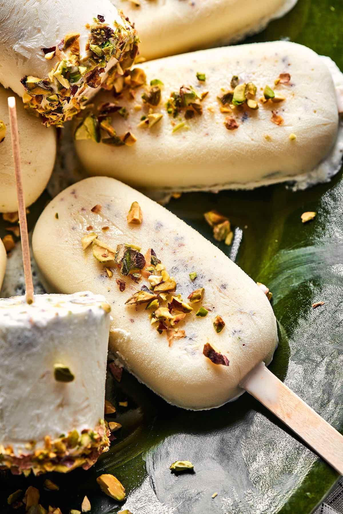 kulfi on a plate with chopped pistachios on top.