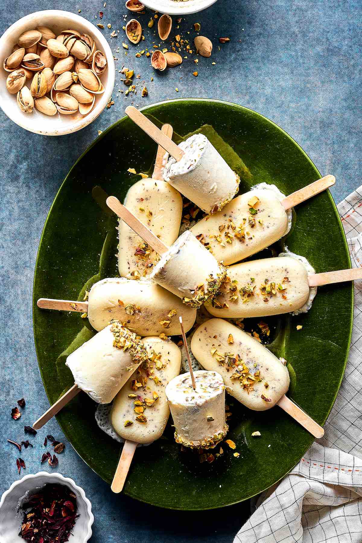 kulfi ice cream on a green plate featuring kulfi with chopped pistachios on top.