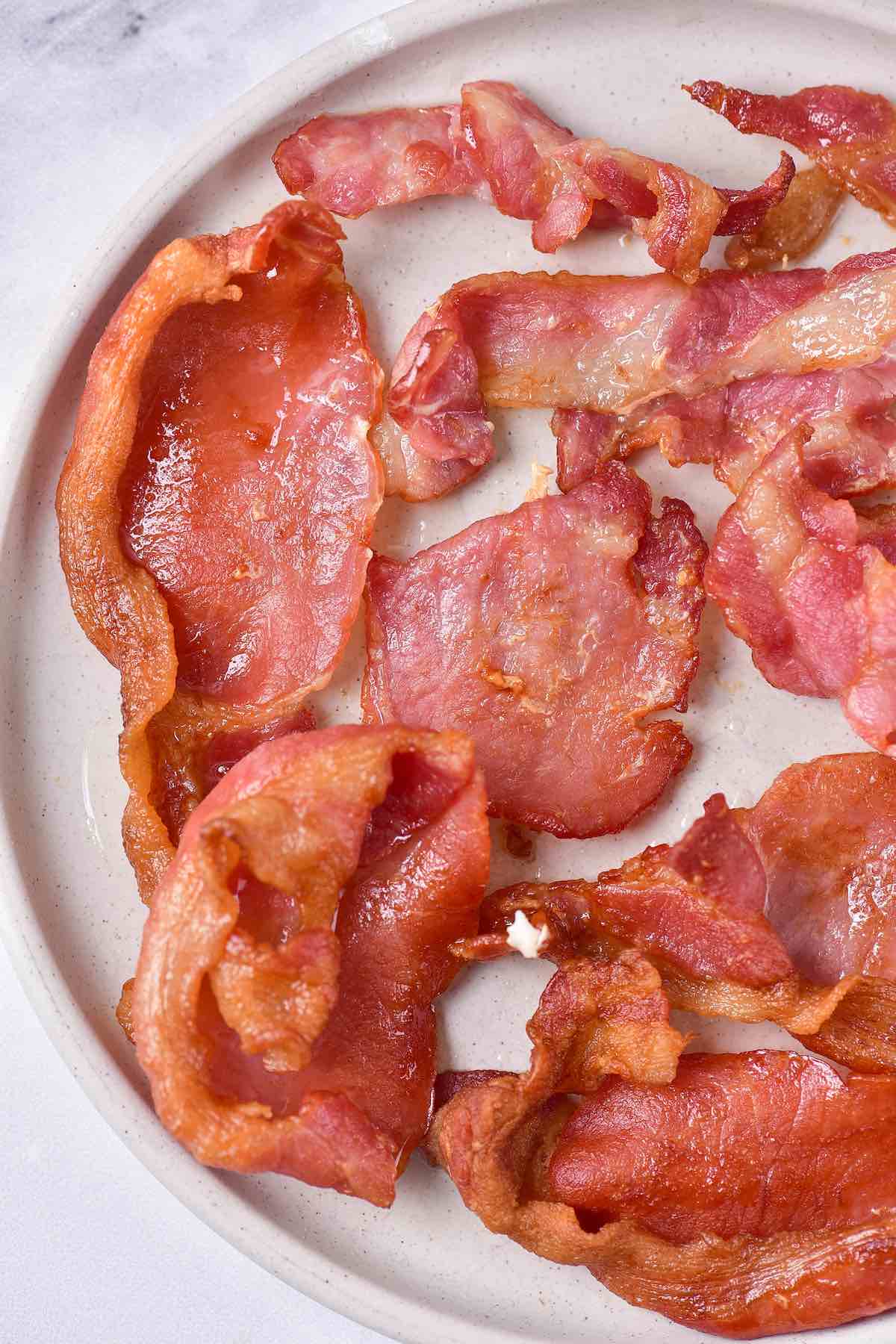 crispy air fryer bacon on a white plate.