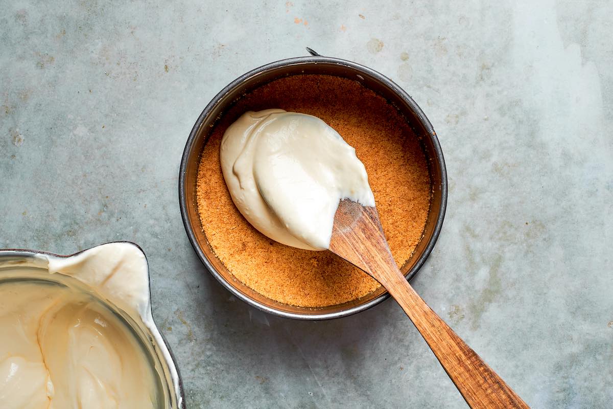 spreading cheesecake filling over the graham cracker crust.