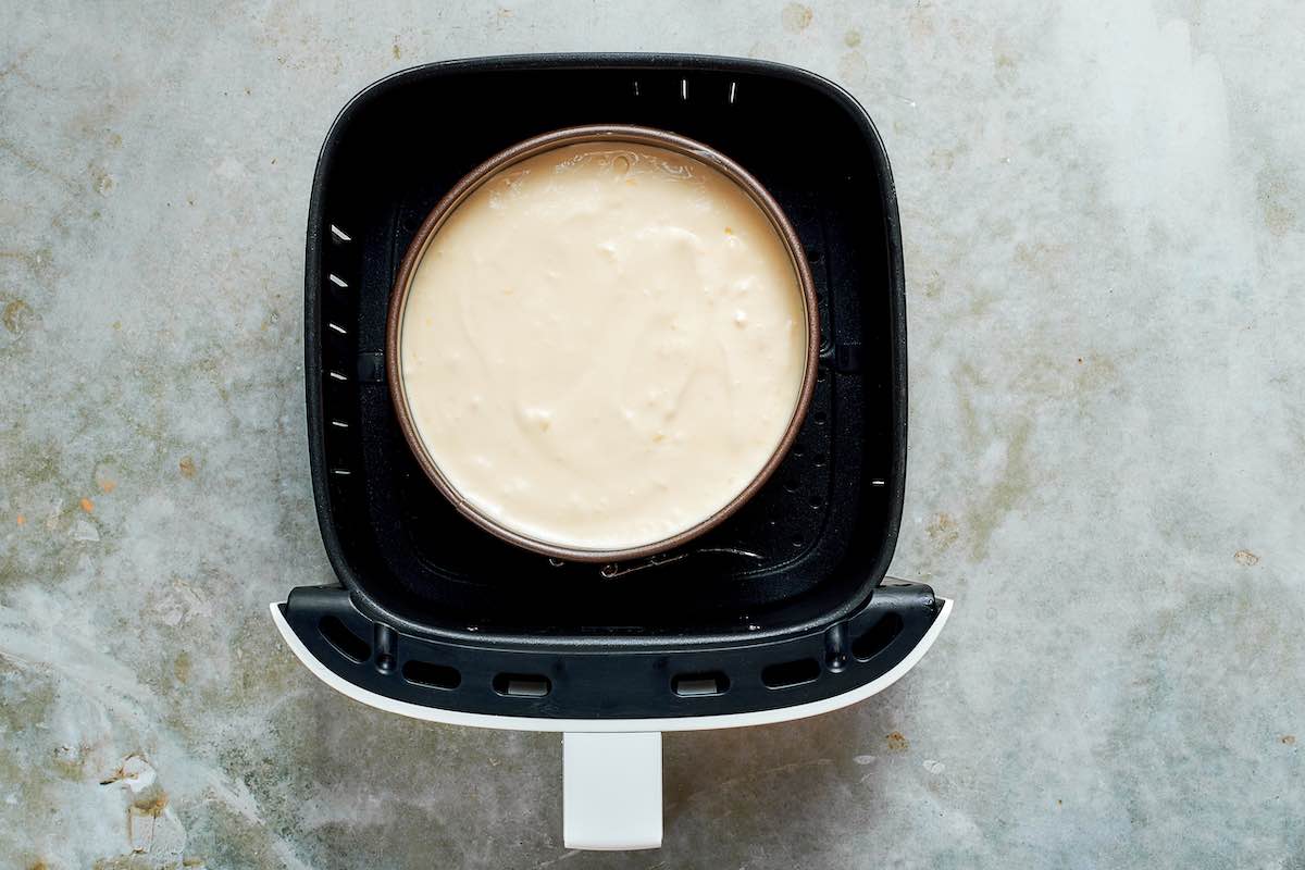 unbaked cheesecake in the air fryer basket.