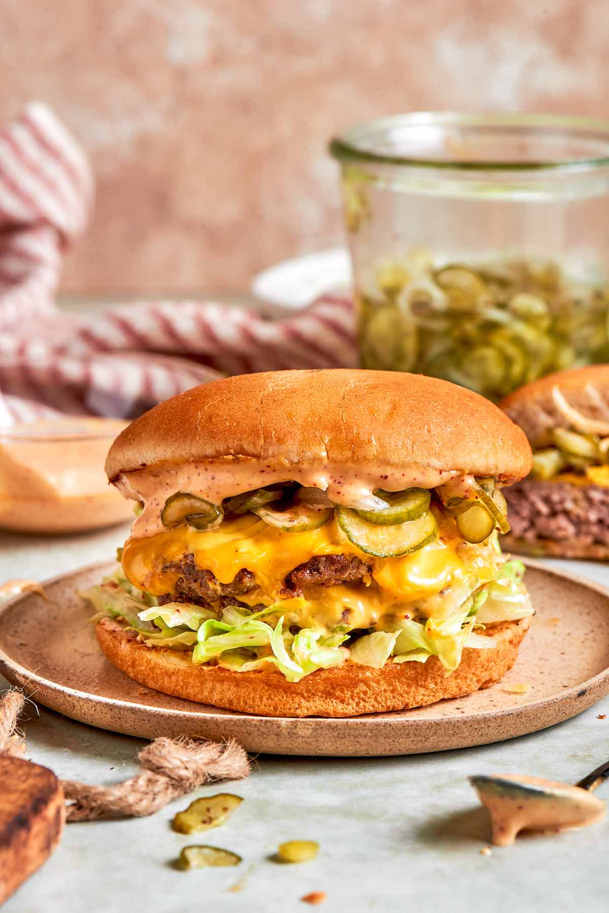 air fryer smash burger with lettuce, cheese, pickles, and smash burger sauce on a plate.
