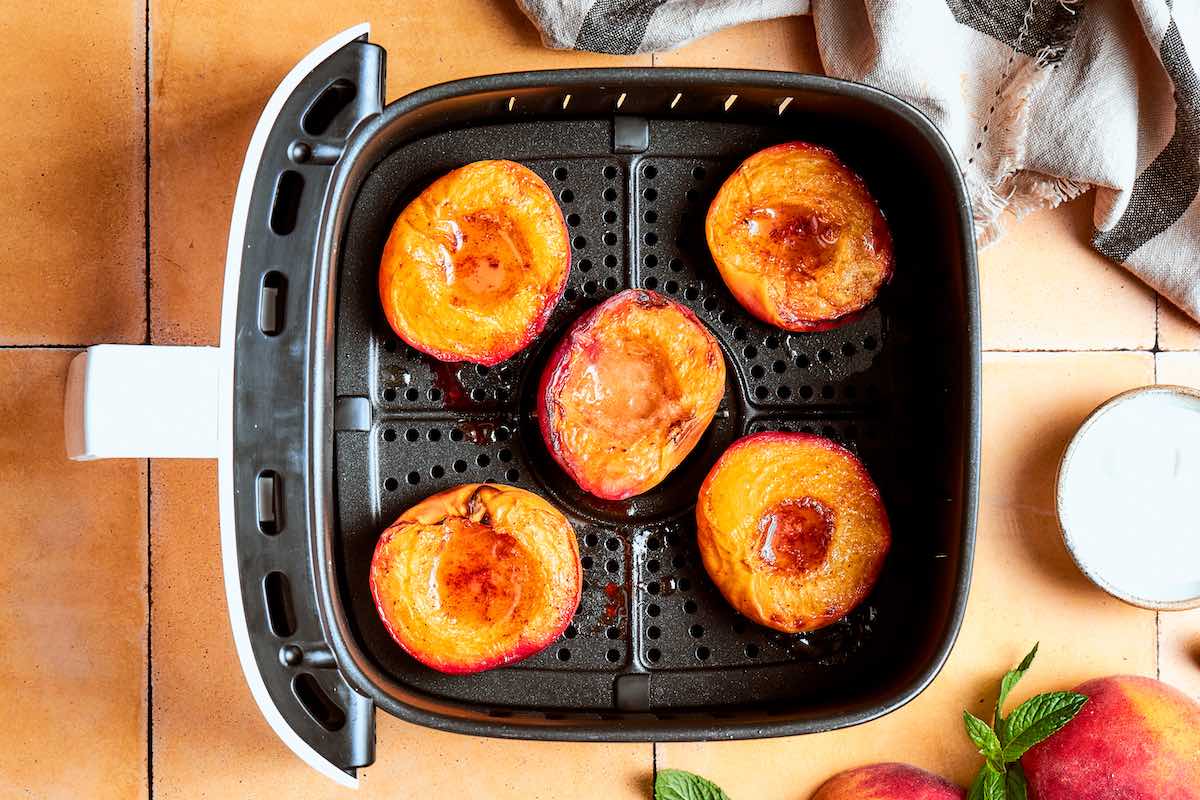 air fried peaches in the air fryer basket.