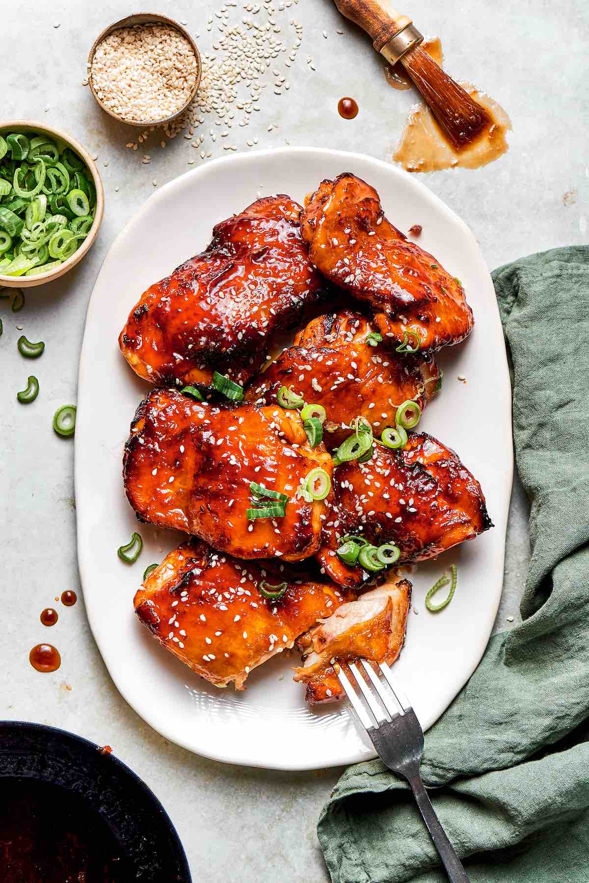 air fryer teriyaki chicken on a white serving dish with green onion on top.