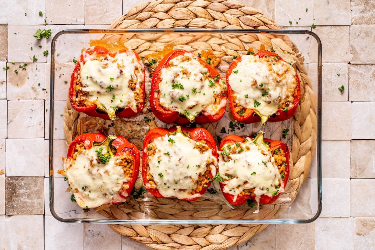 baked ground pork stuffed peppers in a baking dish.