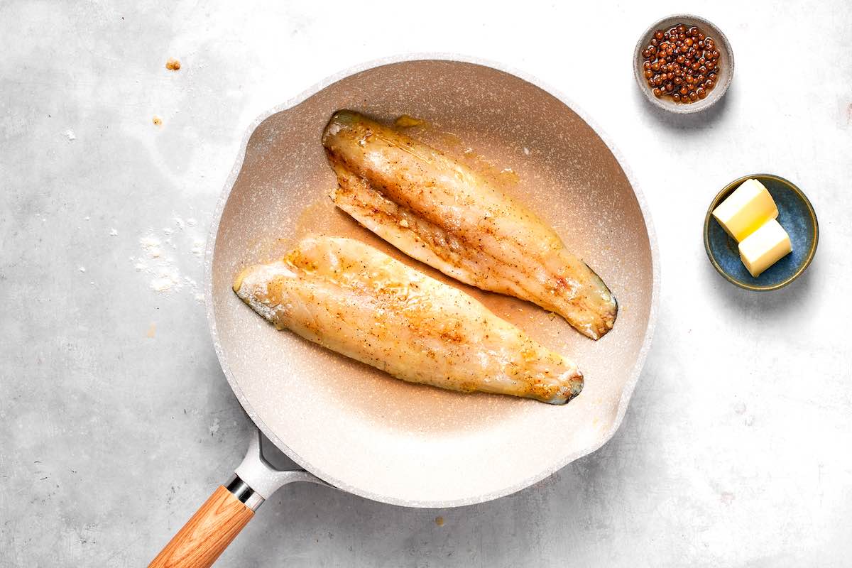 walleye fillets cooking in a skillet.