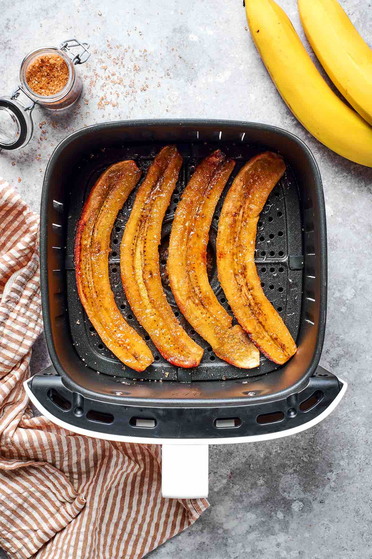caramelized banana halves in the air fryer basket.