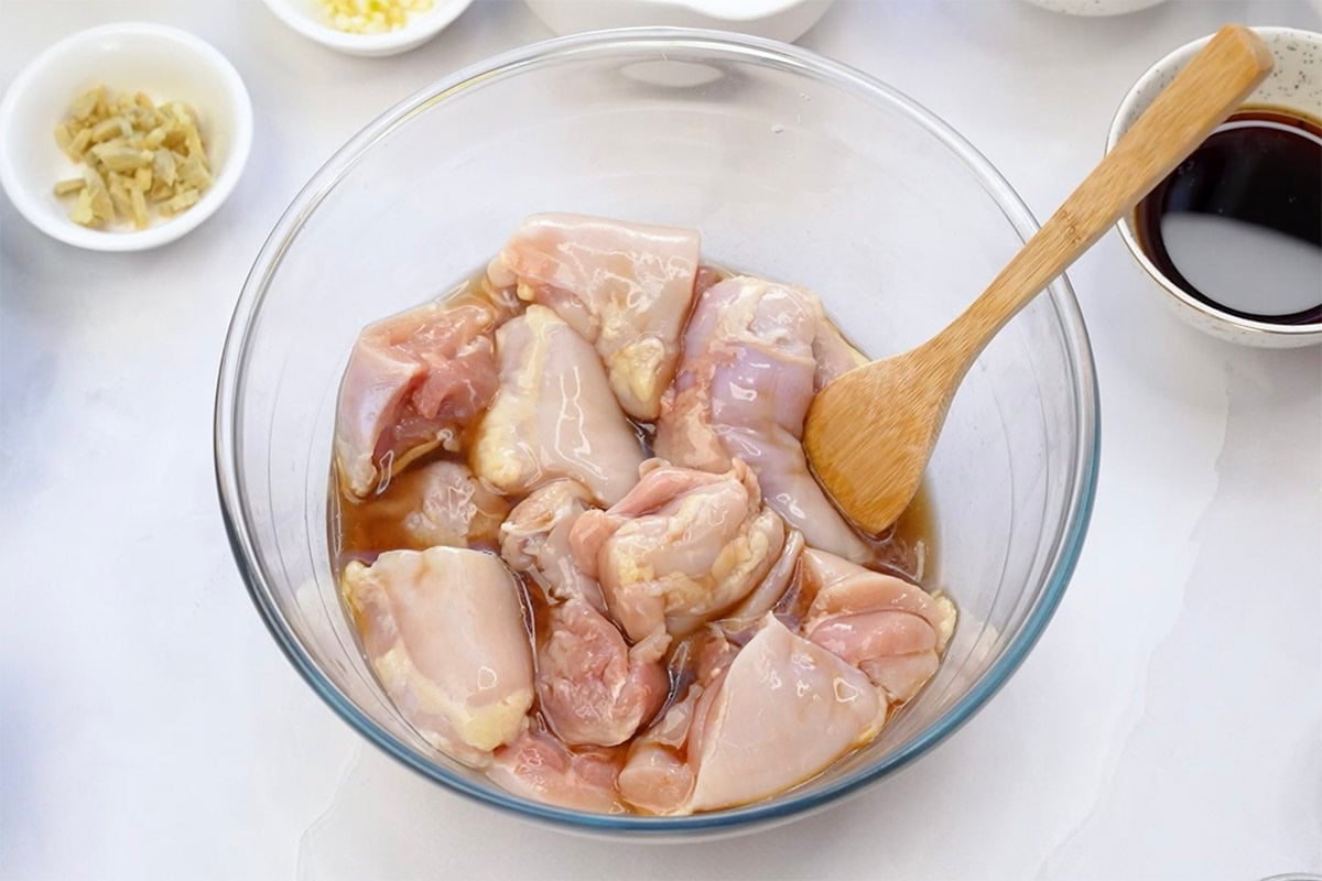 raw chicken in a bowl with marinade.