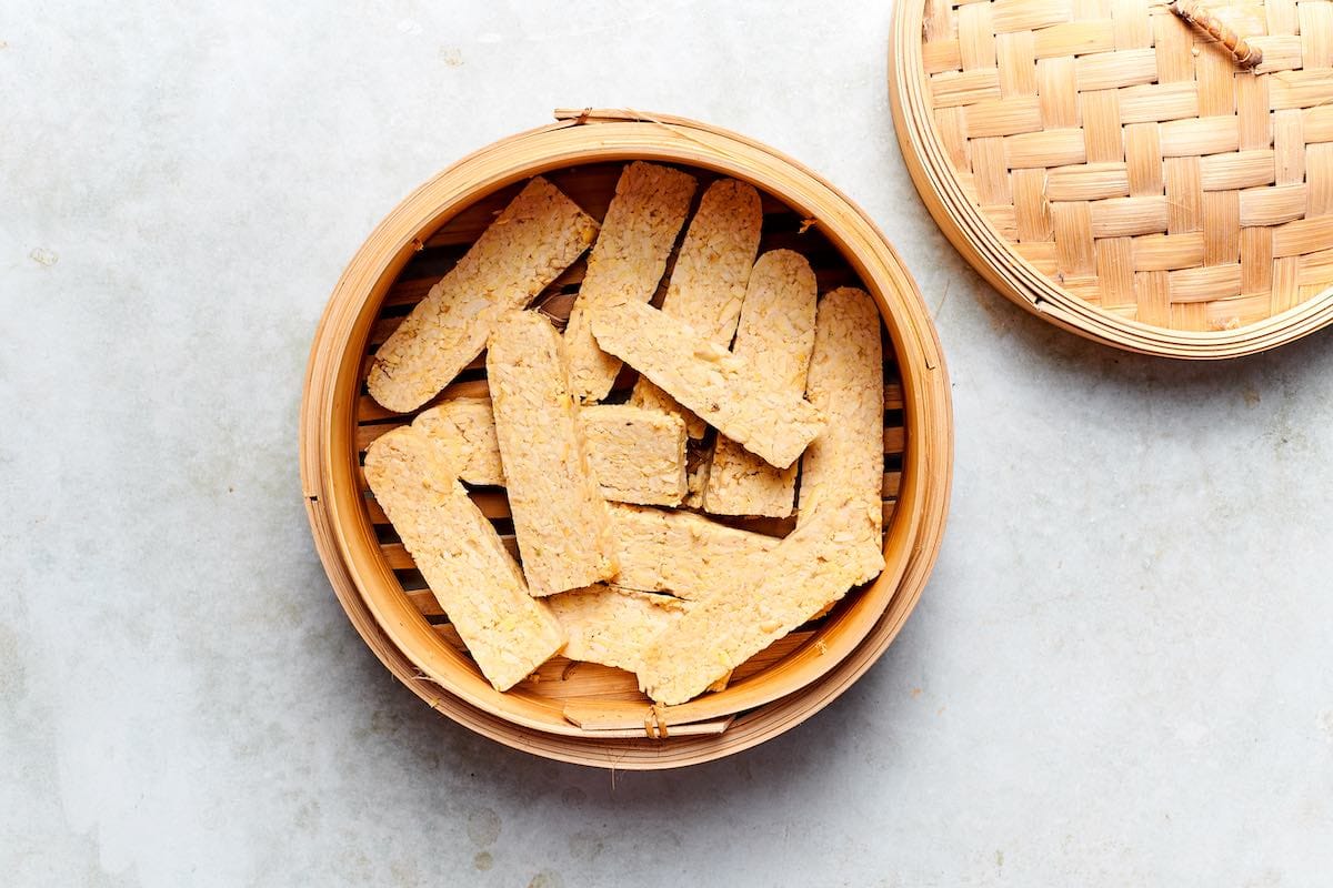 steaming tempeh slices in a steamer.