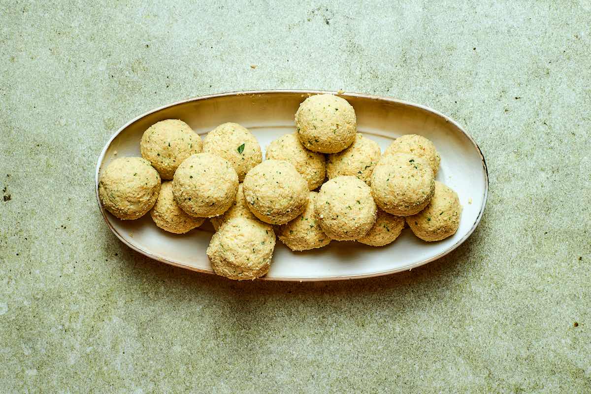 shaped uncooked falafel on a plate.