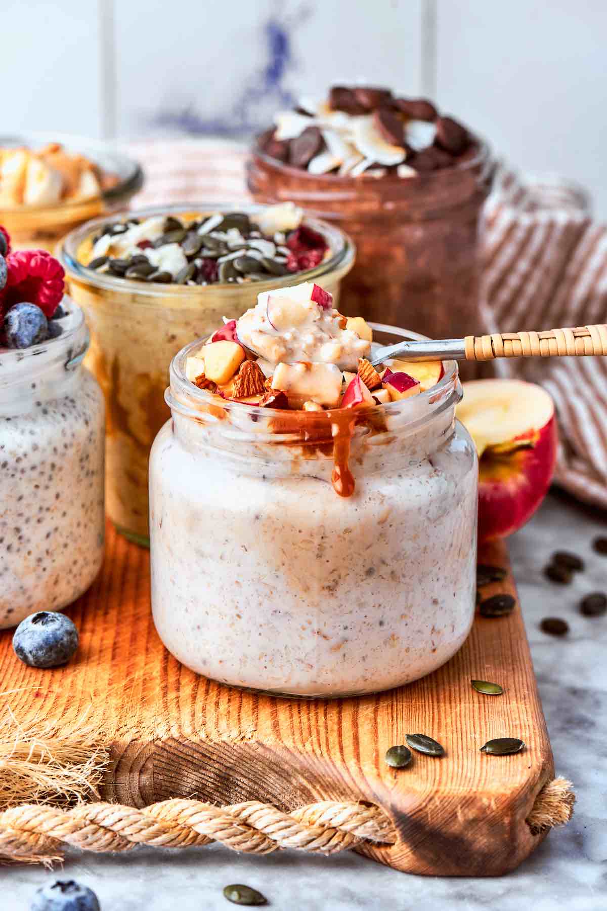 overnight oats in five jars with various toppings.